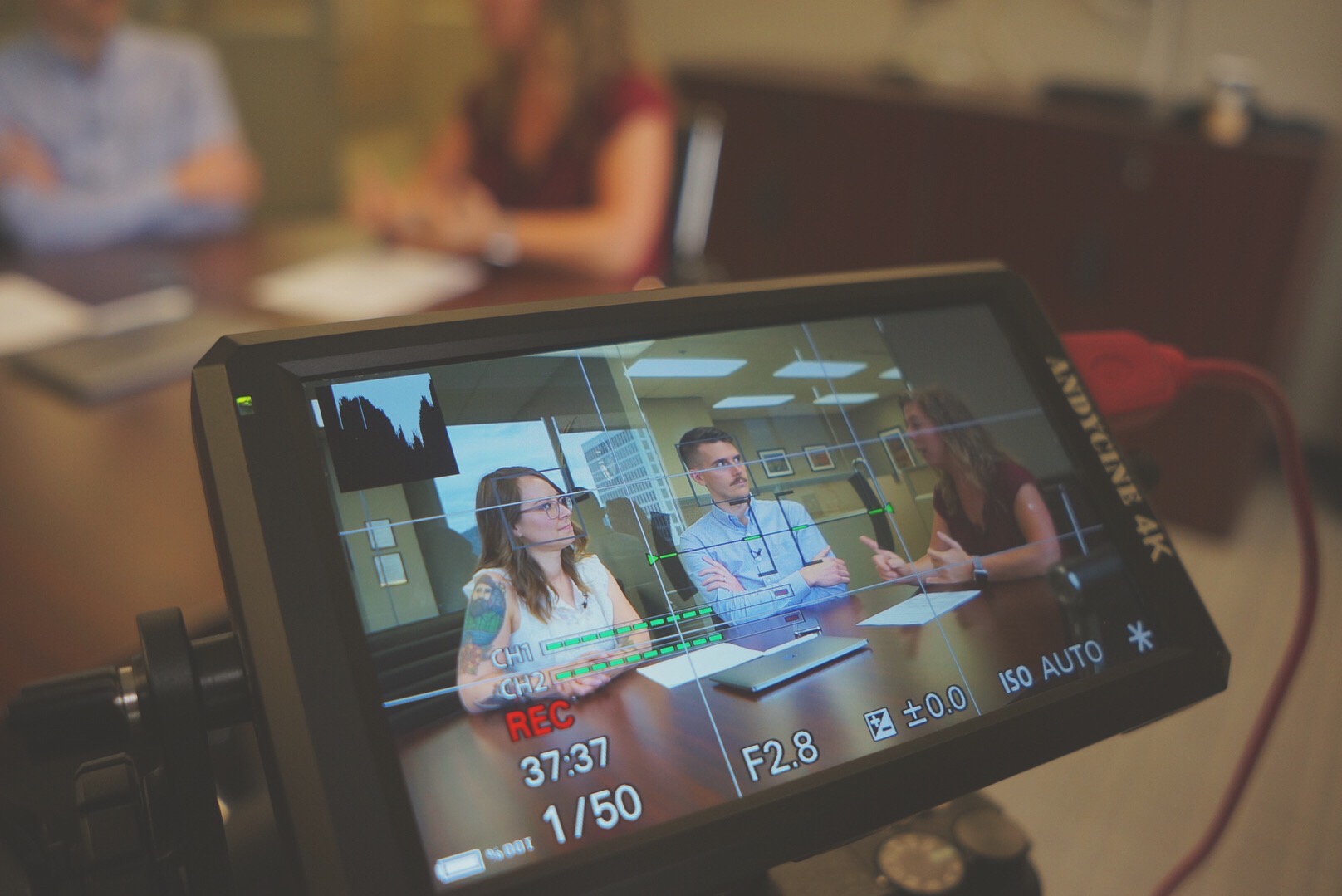 video monitor shows people talking and some nerdy info